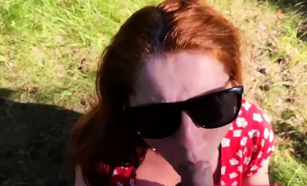 Kinky redhead with big tits gives a blowjob outdoors