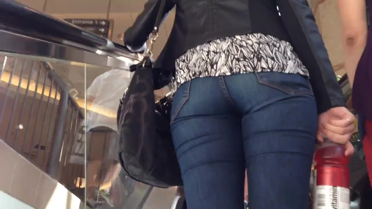 Denim jeans ass going up the escalator