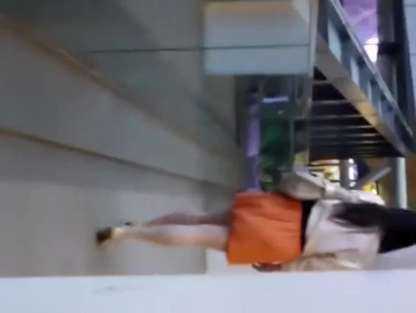 Woman in orange skirt upskirted