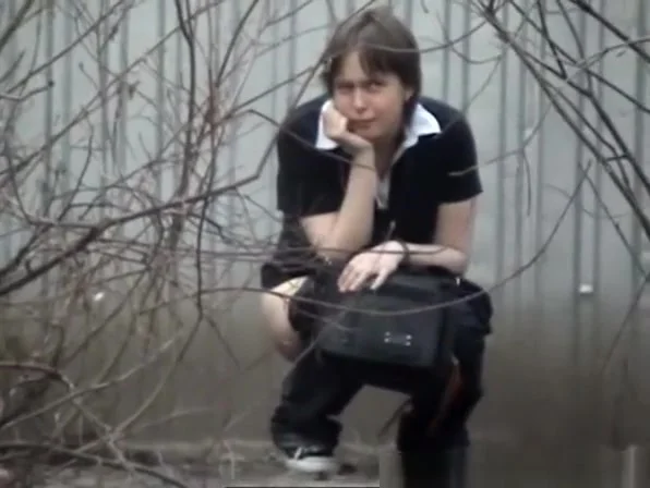Two girls peeing outdoors
