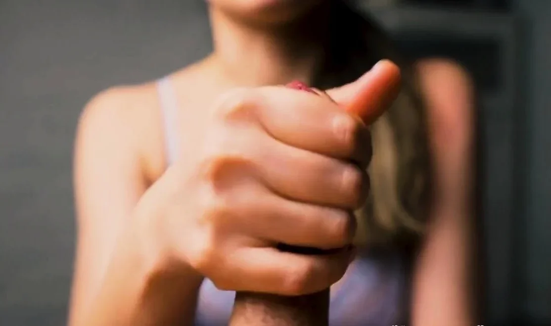 Red-lipped beauty gives an intense handjob to her man
