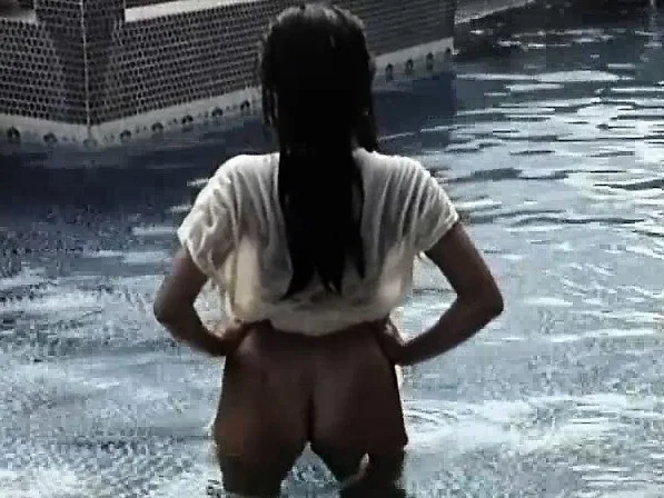 Satomi stands in the pool and moves her clothes around to give a show