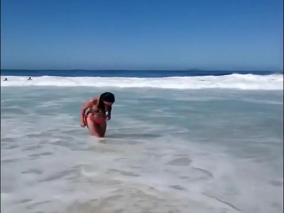 Large-assed harlot wears a flimsy bikini to the beach