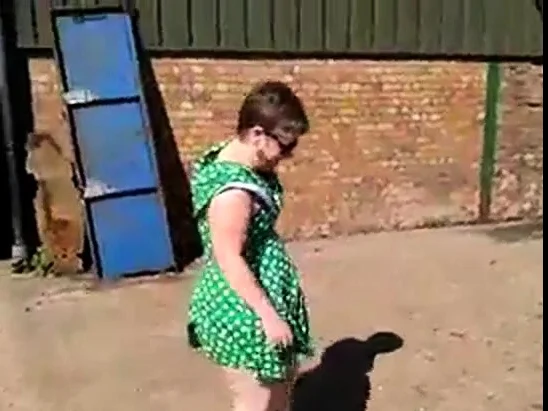 Flashing in green dress and white stilettos