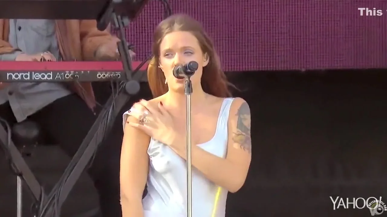 Attractive inked singer shows off one of her tits at a show