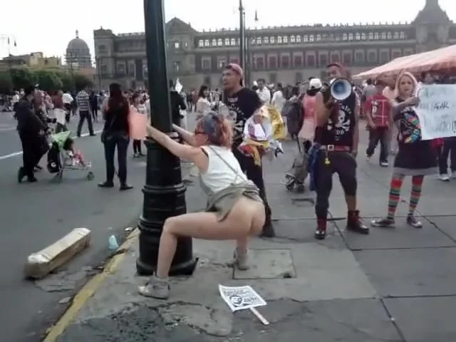 Female agitator pees and poops on a poster at a rally in protest to the government