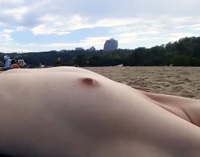 Girl caresses herself on a nude beach