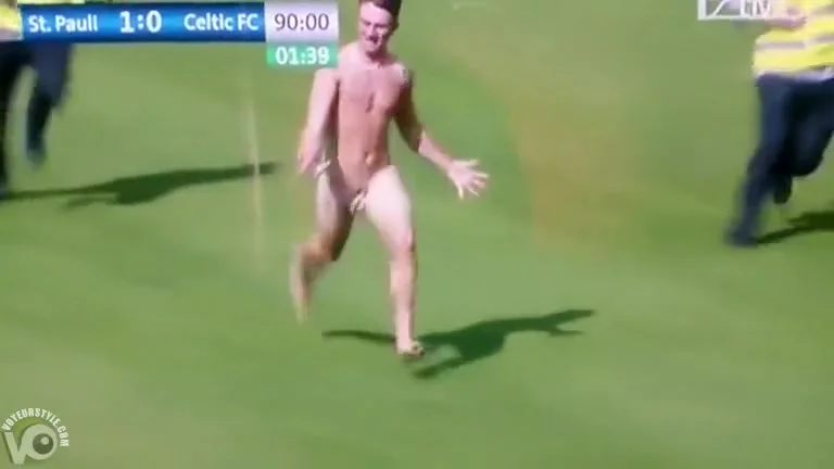 Streaking guy runs around the football pitch