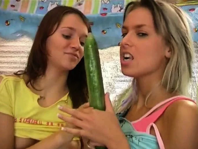 Two irresistible lesbians please each other's pussies with a cucumber