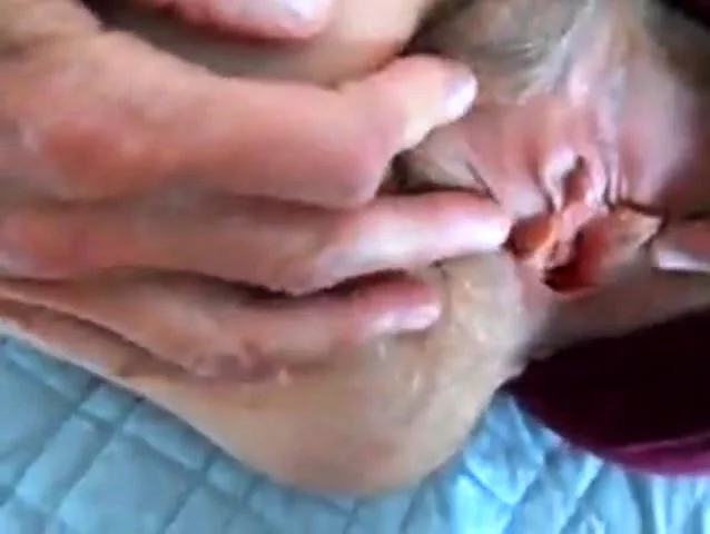 parting her panties to show hairy pussy and hard clit
