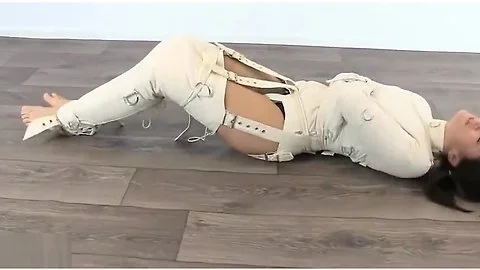 Girl trapped in straitjacket, bound legs.