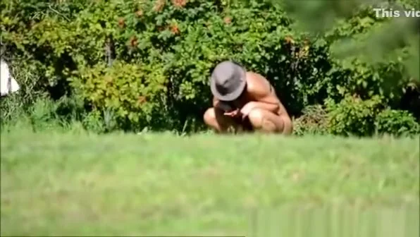 Peeing in the bushes in the meadow