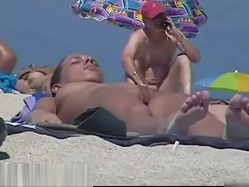 Nude beach with a sexy couple in focus