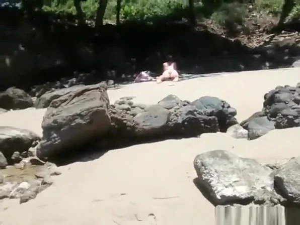 secretly films woman in bikini sunbathing