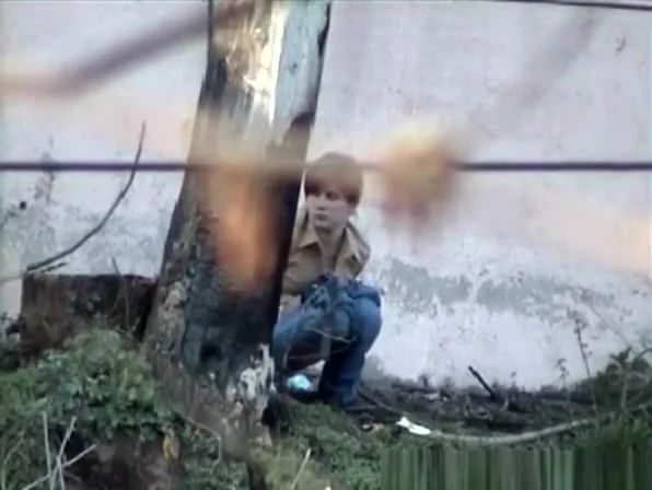 Girl pees next to big wall